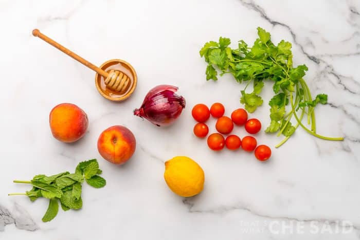 Fresh Peach Salsa ingredients on white marble background