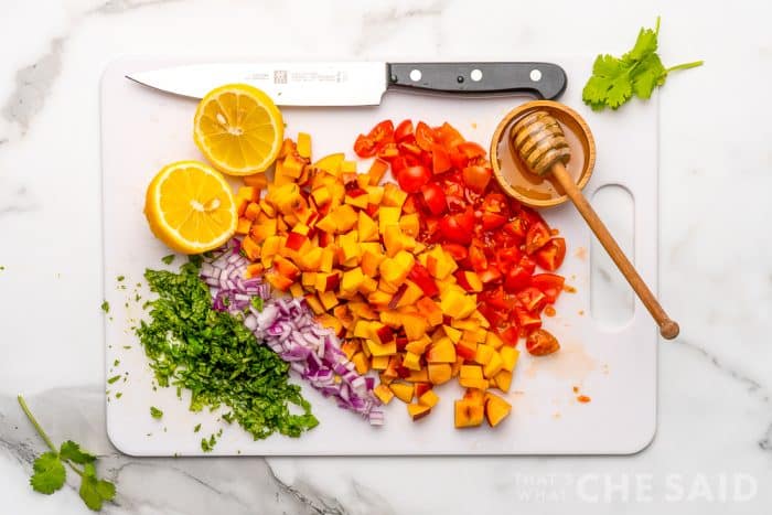 Peach Salsa ingredients on white cutting board diced to same size