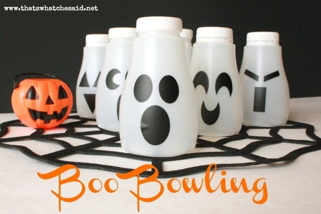 white milk jugs with ghost faces as bowling pins wtih a pumpkin bowling ball