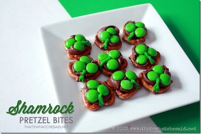 Hershey Kiss Shamrock Pretzel bites on a white plate on green and white background