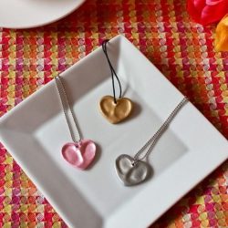 Three thumbprint heart necklaces made from oven bake clay and metallic paint.