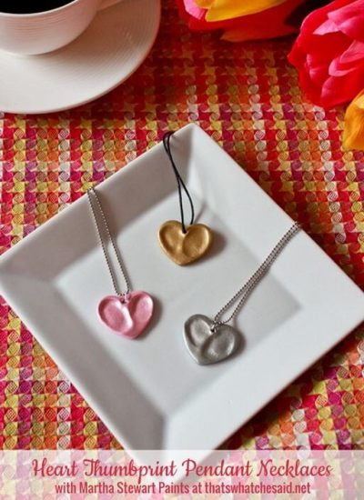 Three thumbprint heart necklaces made from oven bake clay and metallic paint.