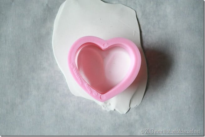 Showing how to line up heart cookie cutter to grab both thumbprints to make the charm