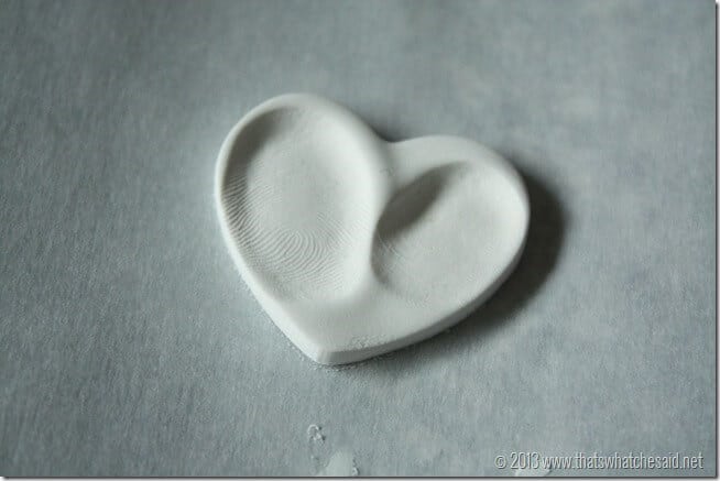 Clay heart with two thumbprints in the shape of a heart. Waiting for a jump ring hole.