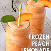Two mason jars filled with Peach Lemonade Slushie, garnished with a peach slice, mint leaf and straw