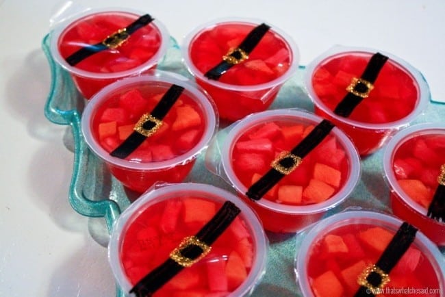 Red gelatin fruit cups with a santa belt drawn on the top to create Santa Fruit Cups