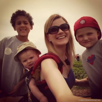 Mom with three boys selfie picture while strawberry picking