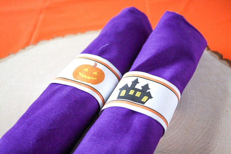 Purple rolled fabric napkins with halloween water bottle labels as napkin rings