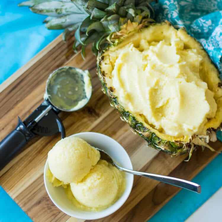 Square Image of fresh pineapple bowl filled with fresh frozen pineapple yogurt and small bowl with 2 scoops