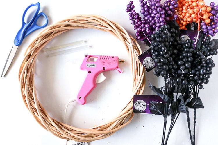 Wreath form, berry sprigs, hot glue gun and scissors