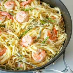 Garlic Butter Shrimp Pasta in skillet on white background