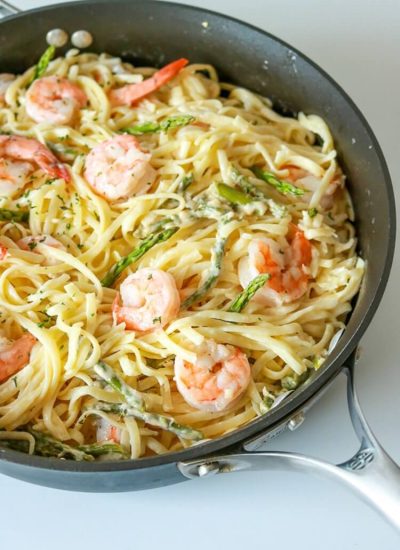 Garlic Butter Shrimp Pasta in skillet on white background