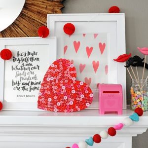 Valentine Mantel with wooden heart that is covered in red and pink buttons for mantel decor