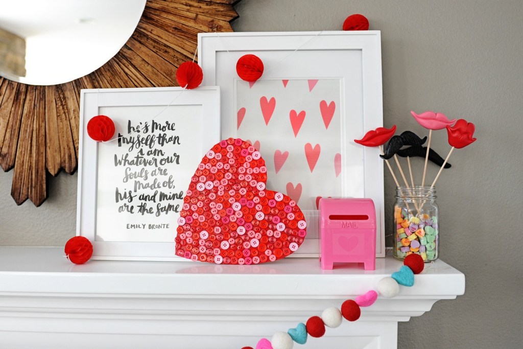 Valentine Mantel with wooden heart that is covered in red and pink buttons for mantel decor