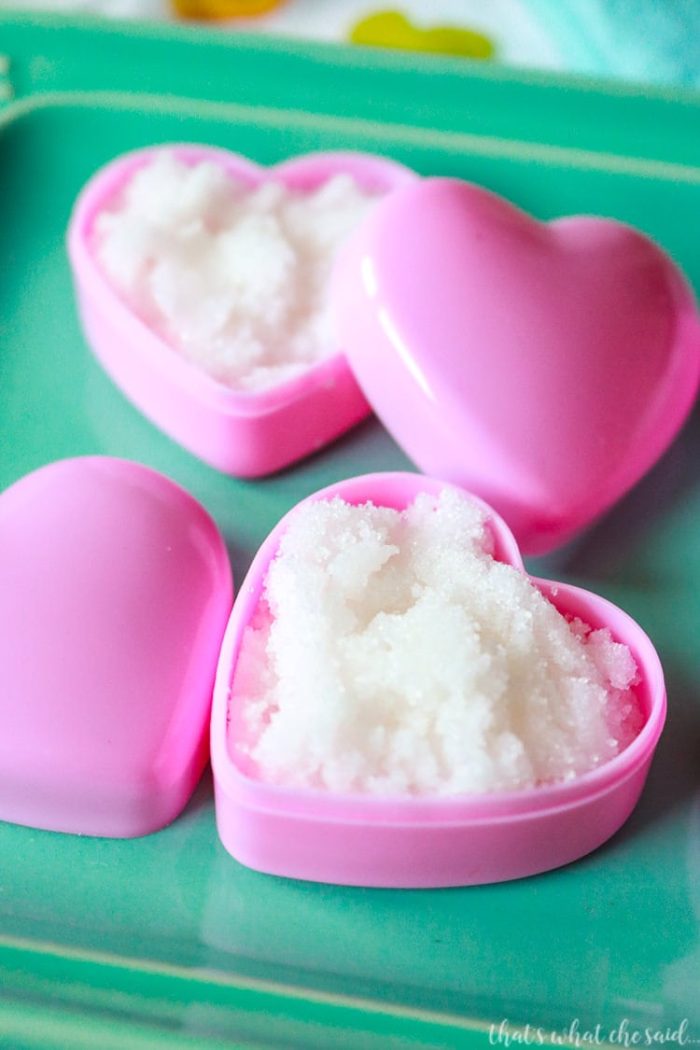 DIY Homemade Lip Scrub made with Sugar and coconut oil in heart containers on aqua plate