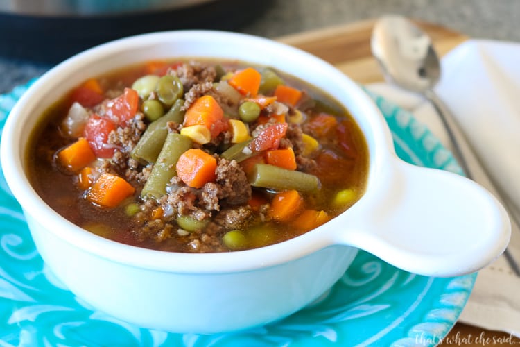 Easy Instant Pot Vegetable Beef Soup in white soup bowl with teal plate and instant pot in background