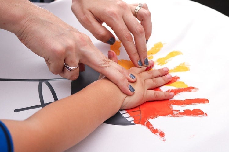 Mother helping Child press handprint onto Father's Day BBQ Grill Apron