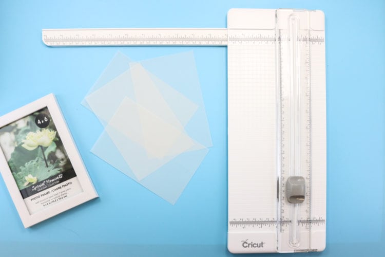 A paper trimmer plus vellum pieces that have been cut to fit frame