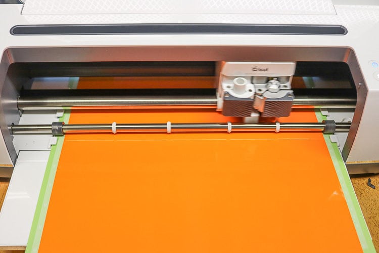 Cricut Maker with Orange Window Cling loaded on a Standard Green Mat