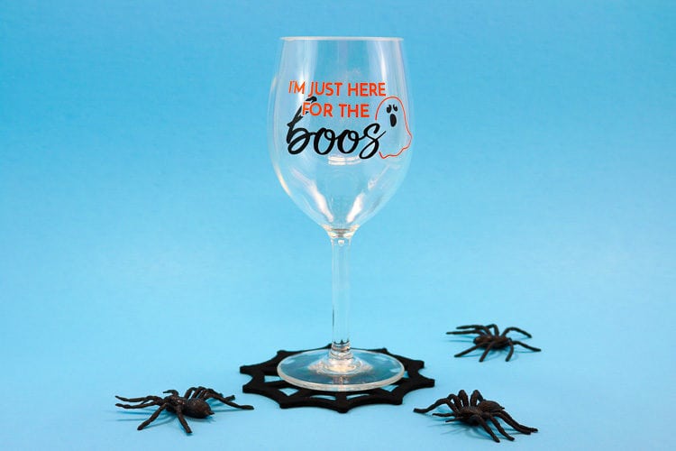 Wine glass with Halloween Vinyl and Spiderweb coaster with fake spiders