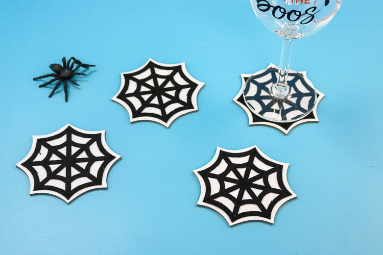 Coasters made with chipboard, vinyl and felt in the shape of spider webs