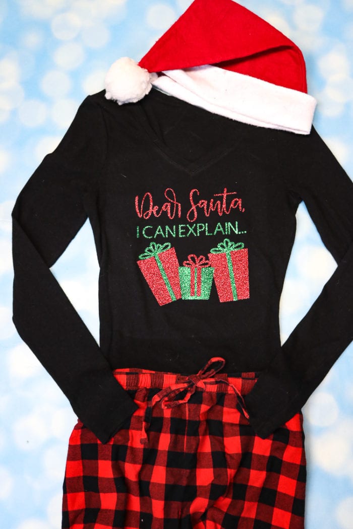 Black PJ top with Cricut Design with Buffalo check PJ pants and Santa Hat. 