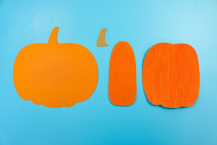 4 parts of the pumpkin each cut in a different material. Cardstock, corrugated cardboard and felt.