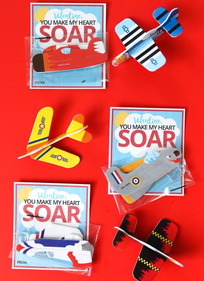 Red background with Airplane Valentine printables with small foam airplanes