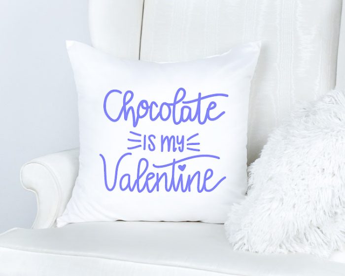 White couch with white pillow that reads Chocolate is my Valentine SVG