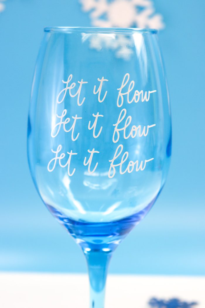 Closeup of Blue Wine Glass with Let it Flow, Let it Flow, Let it Flow in Vinyl