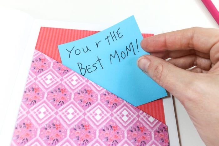Slipping love note from child into paper pocket in back of diy journal