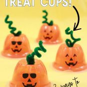 four fruit cups turned upside down and a pipe cleaner stem has been added with jack o lantern face to create pumpkin treat cups