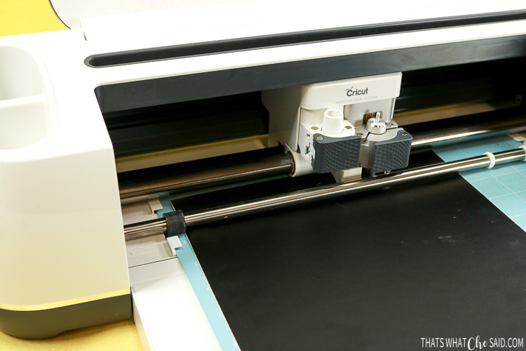 Cricut Maker cutting black craft vinyl into jack-o-lantern faces