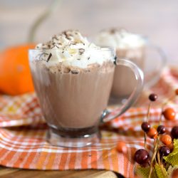 Maple Bourbon Hot Chocolate in clear glass mugs with whipped topping