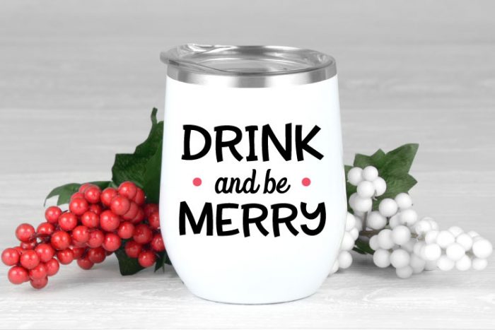White insulated tumbler with "Drink and be Merry" saying in adhesive vinyl.