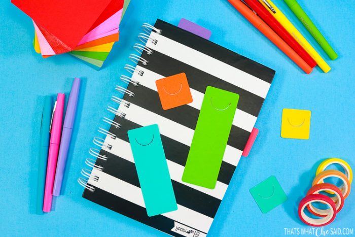 Black and white stripe notebook with rainbow colored pens, post its, markers, washi tape and diy cardstock planner tabs