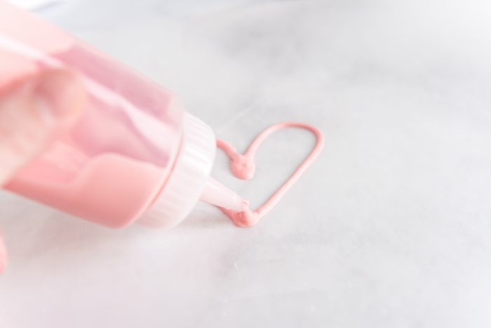 Drawing heart with melted chocolate in a squeeze bottle. 