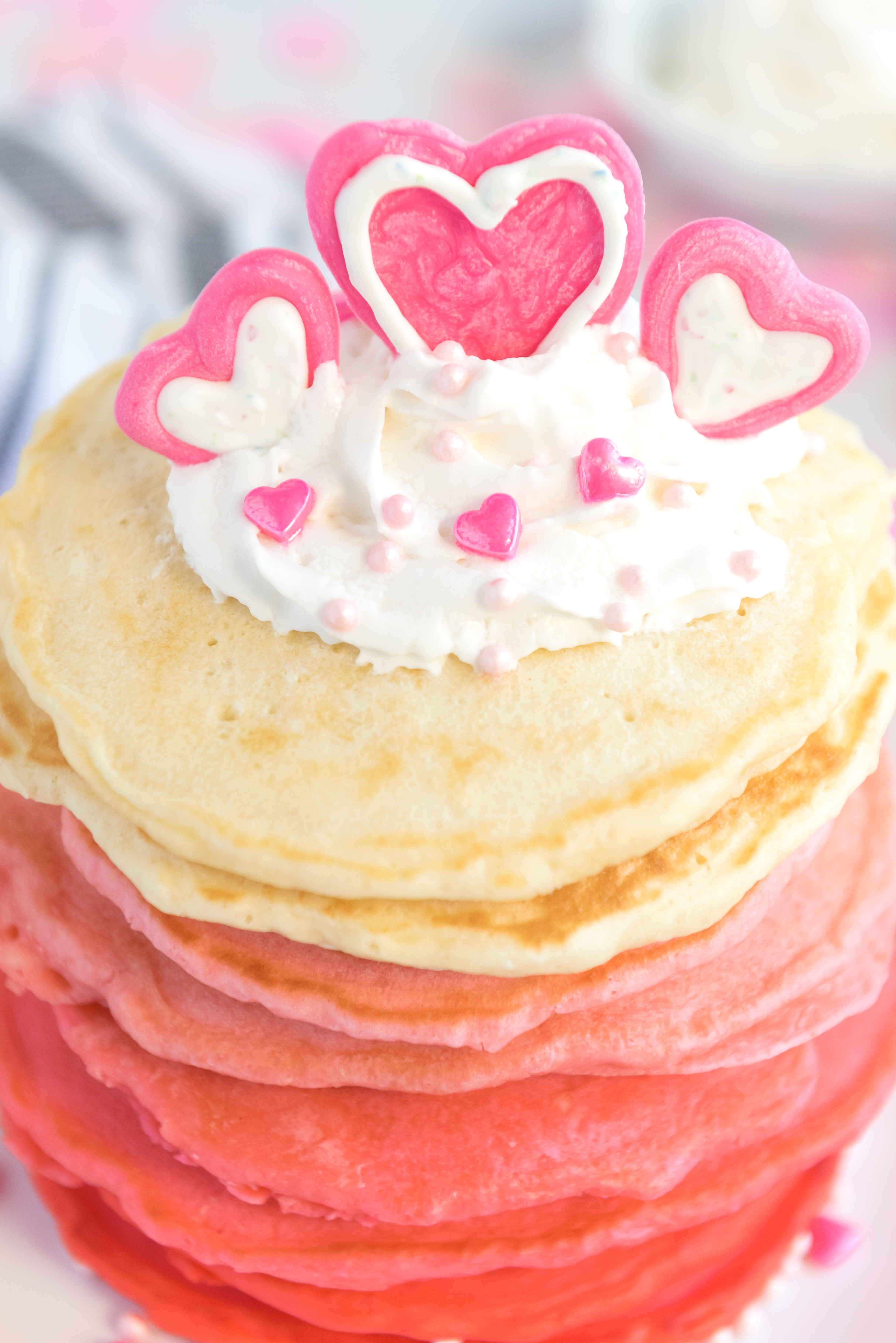 Pancakes stacked from red, dark pink,pink and white