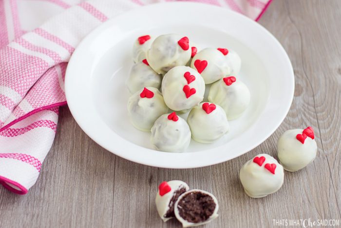 Bowl of finished oreo truffles and a cut open one in front