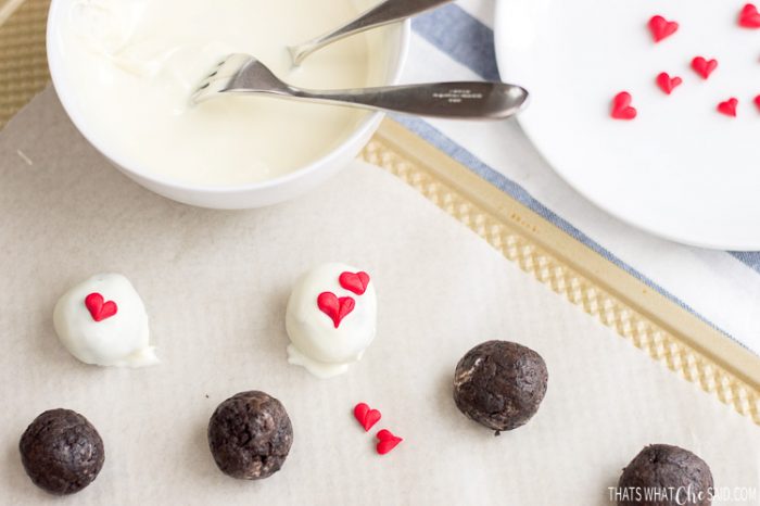 Adding fondant hearts to the tops of chocolate dipped oreo truffles