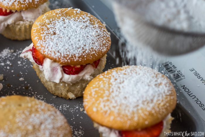 Dusting the tops of the cupcakes with powdered sugar