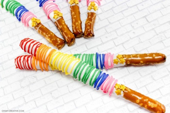 Pretzel rods dipped in white chocolate and then drizzled with colored chocolates in rainbow order.