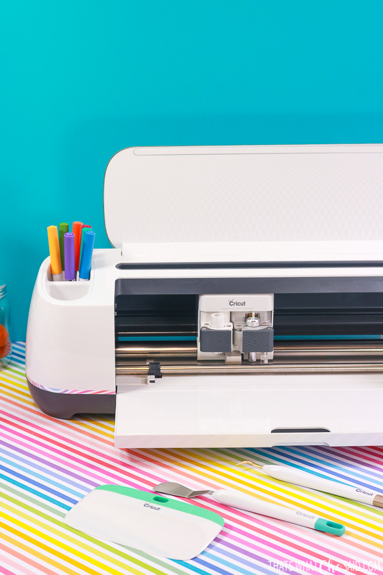 Cricut Maker on Rainbow Posterboard with some adaptive tools