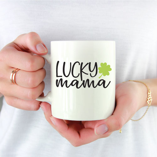 woman holding white coffee mug with teheh Lucky mama SVG in black and green vinyl 