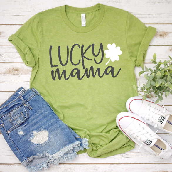 Green T-shirt with Lucky Mama designwith white converse and jean shorts and plant offering outfit idea