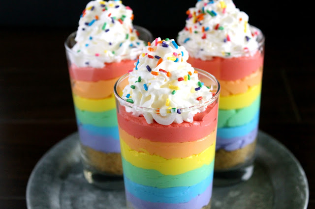 Cheesecake Parfait glasses with cheesecake layers in colors of the rainbow, Whipped topping with rainbow sprinkles on top