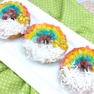 Air Fryer Donuts decorated with Fruity Pebbles in rainbows and coconut as clouds