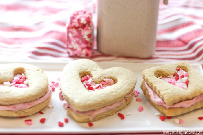 A long white plate with a heart circle and square shortbread sandwich cookie with heart centers