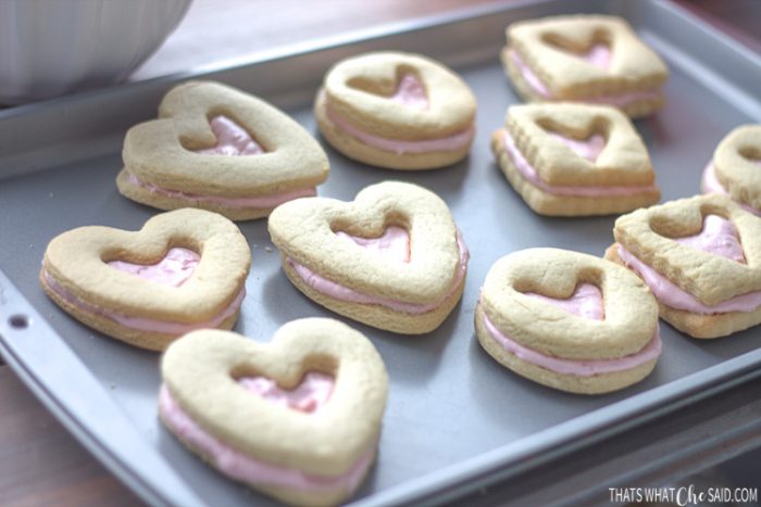 Baking sheet with shortbread cookies sandwiching raspberry filling