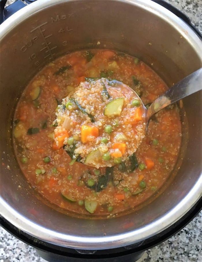 Shot looking down into the instant pot of soup with ladle full of Vegetable Quinoa Soup